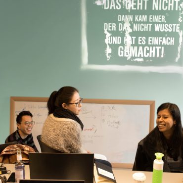 Junge Menschen aus unterschiedlichen Kulturen vor einem Whiteboard